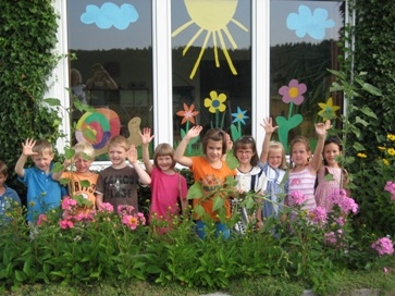 Winkende Kinder vor dem Kindergarten Haigermoos